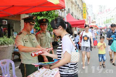 宣傳人員向過路群眾和游客發放宣傳小冊子